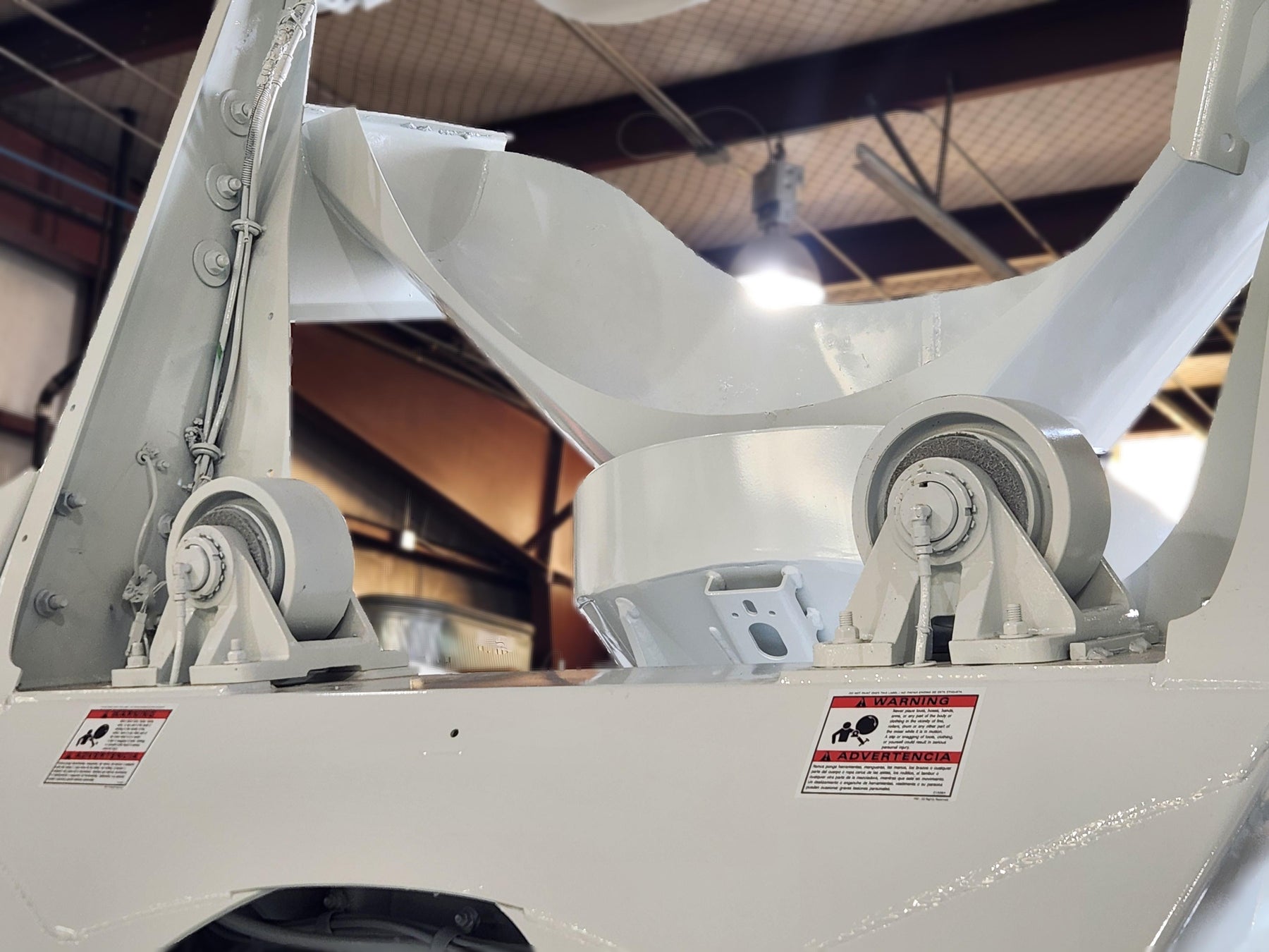 Mechanic working on a putzmiester concrete pump truck in a western mixer service bay