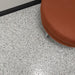 Installed Coyote flake epoxy floor in a commercial room with black wall and office table.